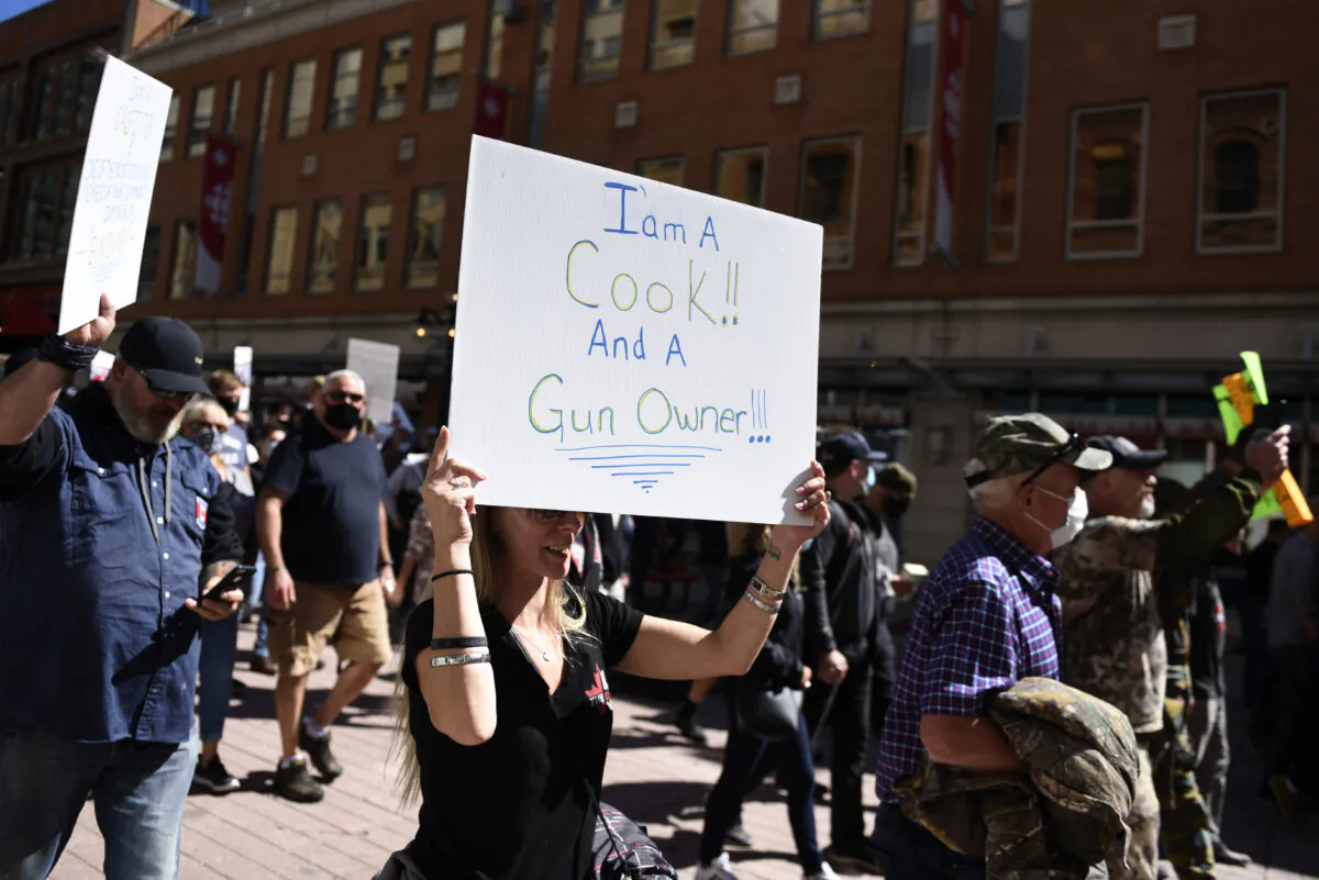 Gun owners hold signs as they participate in a rally organized by the Canadian Coalition for Firearm Rights against the government's new gun regulations, in Ottawa on Sept. 12, 2020. (THE CANADIAN PRESS/Justin Tang)