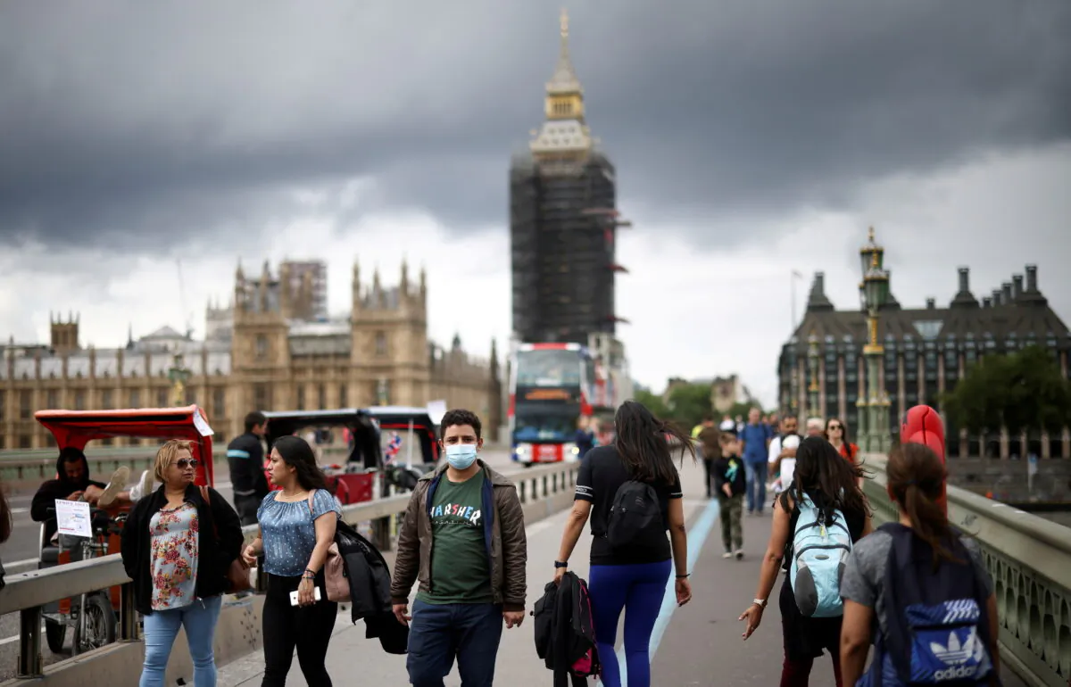 People, some wearing protective masks, walk over Westminster Bridge, amid the COVID-19 pandemic, in London on July 4, 2021. (Henry Nicholls/Reuters)
