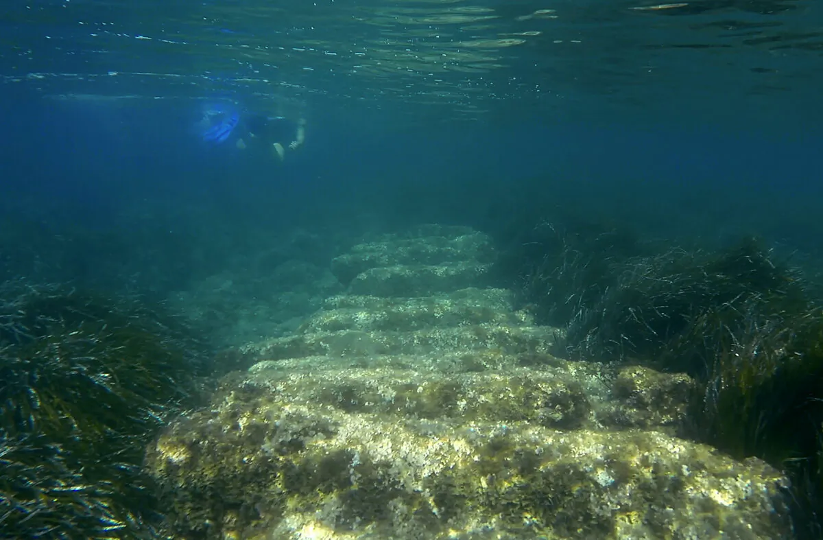 Cyprus Antiquities Department official Yiannis Violaris snorkels over submerged stone remains of the ancient harbor next of Amathus ancient city, in the eastern Mediterranean island of Cyprus, on July 1, 2021. (Petros Karadjias/AP Photo)
