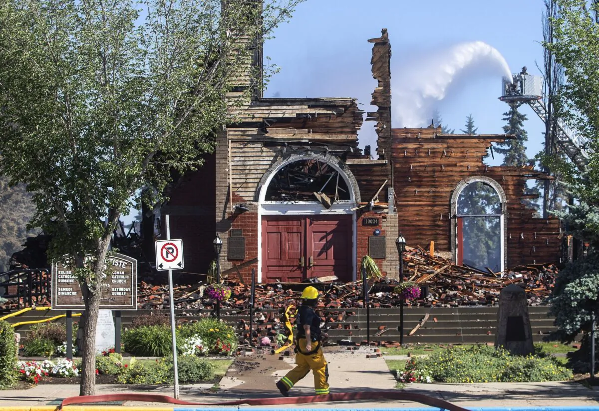 Firefighters put out hot spots at what remains of St. Jean Baptiste Parish Catholic Church in Morinville, Alta., after a fire on June 30, 2021. (The Canadian Press/Jason Franson)