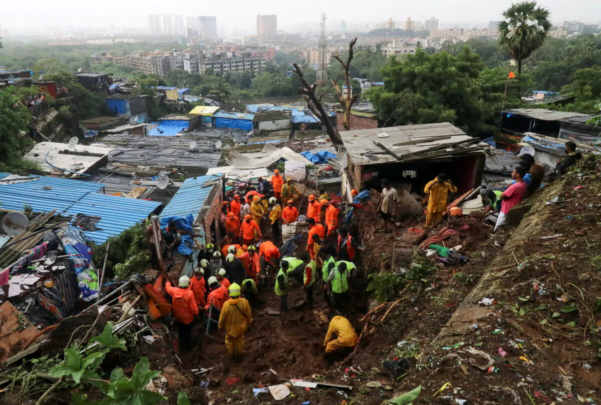 Rescue workers search for survivors after a residential house collapsed due to landslide caused by heavy rainfall in Mumbai, India, July 18, 2021. (REUTERS/Niharika Kulkarni)