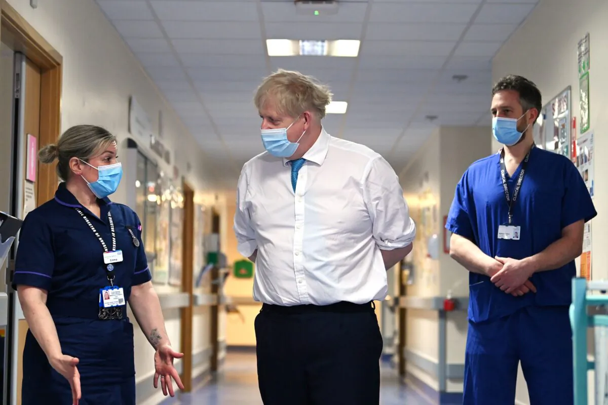 Prime Minister Boris Johnson (centre) speaks with Emma Sweeney, associate director of nursing surgery, during a visit to Colchester Hospital in Essex, Britain, on May 27, 2021. (Glyn Kirk/PA)
