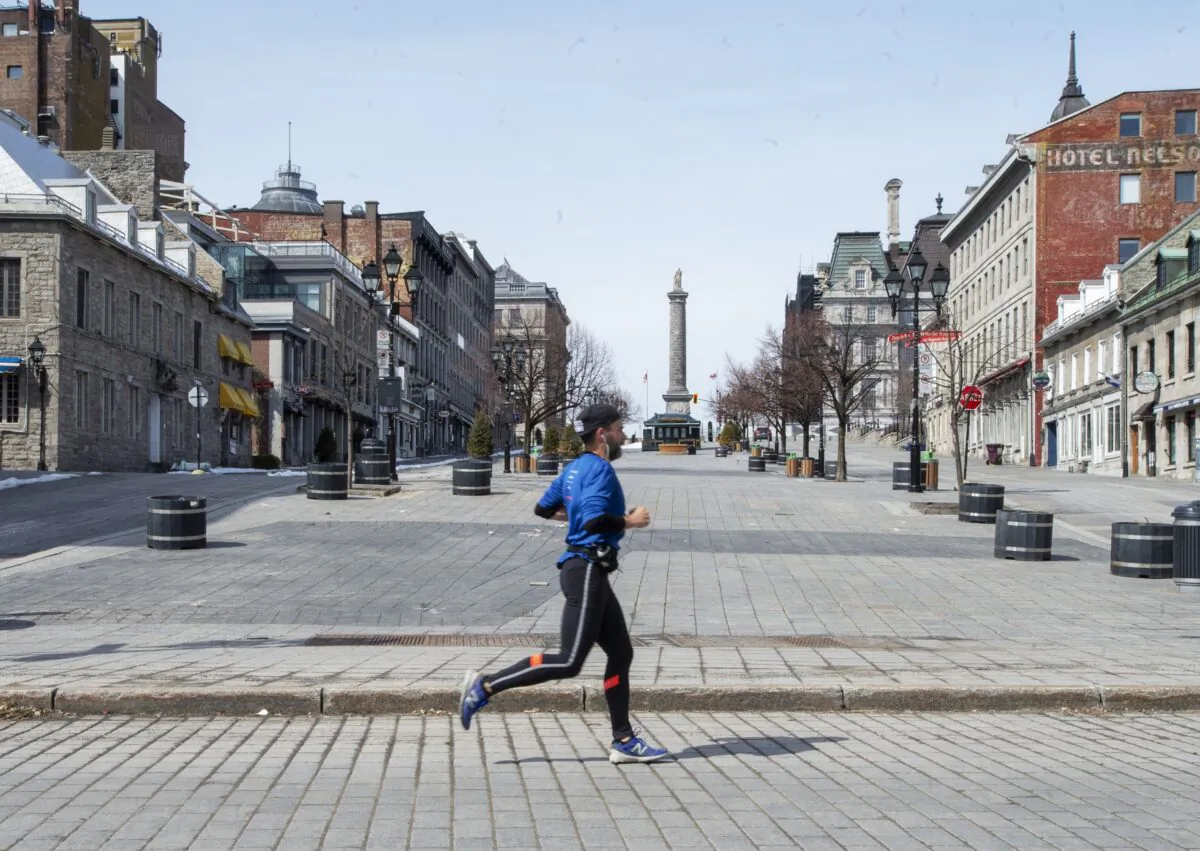 A man jogs through an empty Place Jacques Cartier in Montreal on March 25, 2020, as COVID-19 pandemic restrictions began in Canada. (The Canadian Press/Ryan Remiorz)
