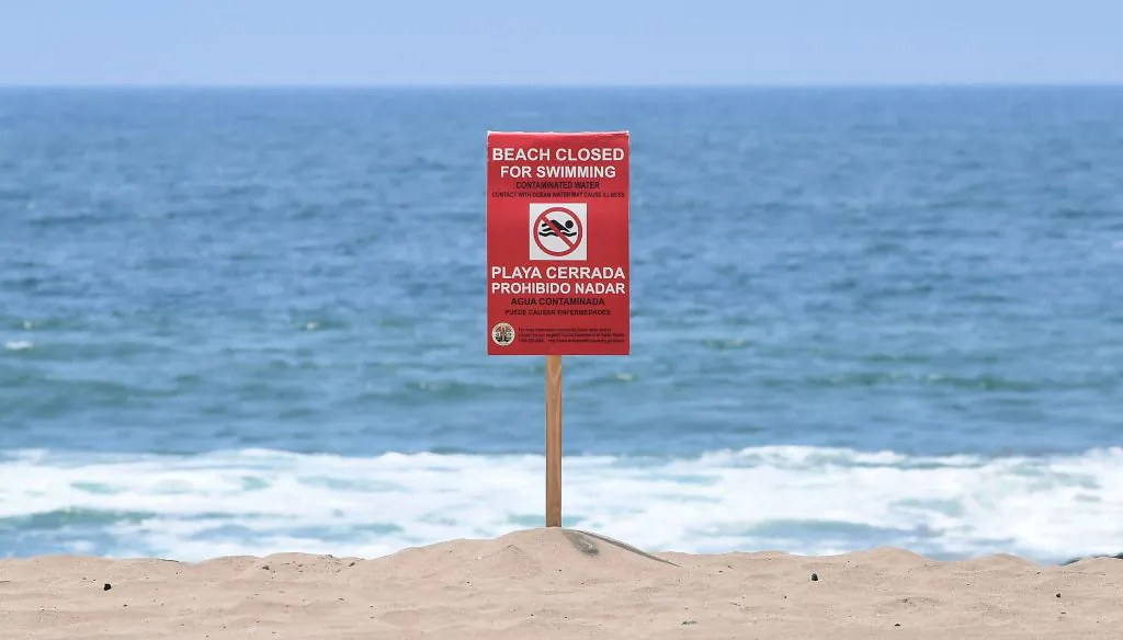 A sign indicates that the Dockweiler State Beach is closed to swimming after a sewage spill in Playa del Rey, in Los Angeles County, Calif., on July 13, 2021. (Frederic J. Brown/AFP Via Getty Images)