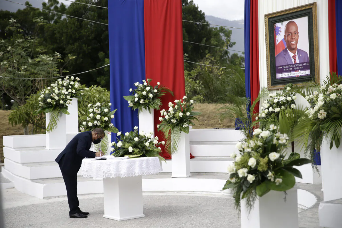 A man puts his name into a signature book during a memorial ceremony for late Haitian President Jovenel Moise at the National Pantheon Museum in Port-au-Prince, Haiti, on July 20, 2021. (Joseph Odelyn/AP Photo)