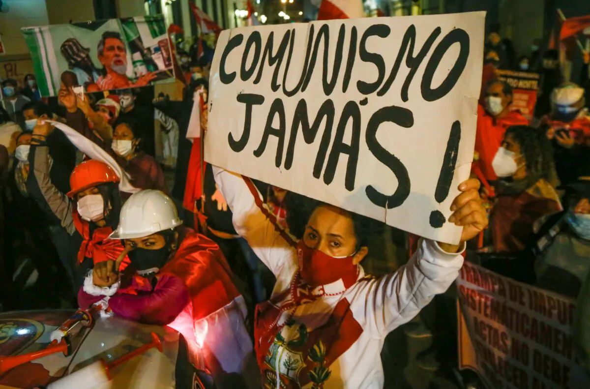 A supporter of presidential candidate Keiko Fujimori holds a banner that reads "Communism Never!" in a march to the government palace in Lima on July 14, 2021, demanding the National Jury of Elections (JNE) investigation allegations of election fraud for leftist candidate Pedro Castillo. (GIAN MASKO/AFP via Getty Images)