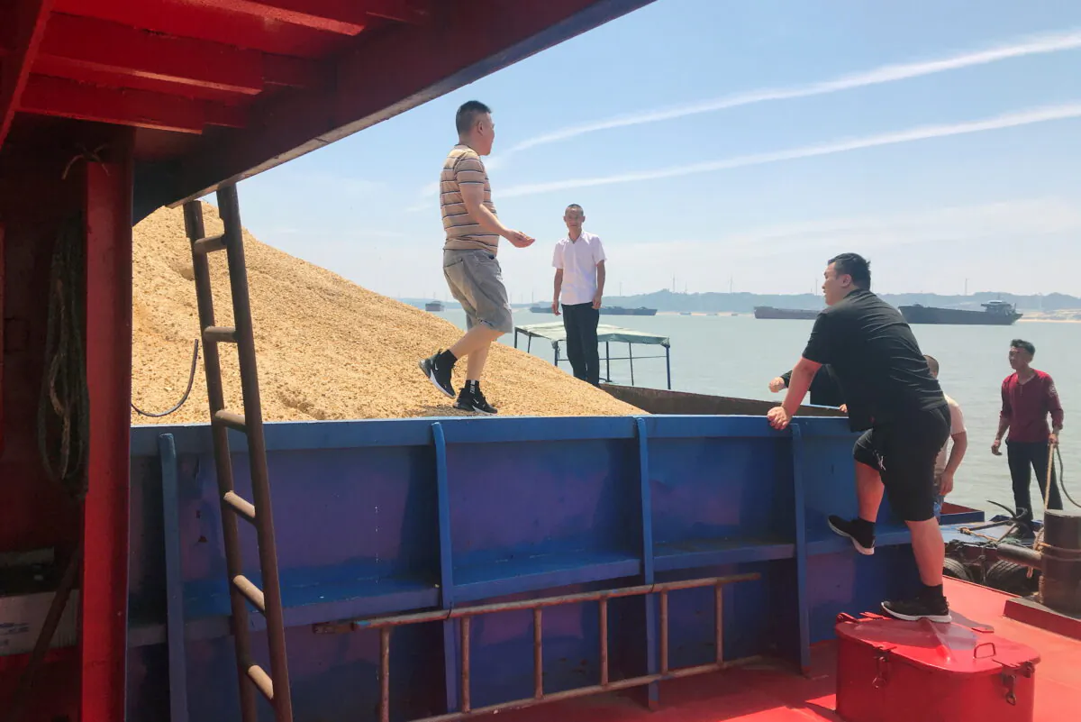 Assessors inspect sand on barges on Poyang Lake in Jiujiang, Jiangxi province, China, on June 23, 2021. (Gabriel Crossley/Reuters)