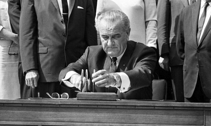 U.S. President Lyndon B. Johnson reaches for a pen to sign the Food Stamp bill in Washington on Sept. 27, 1967. (Bob Daugherty/AP Photo)