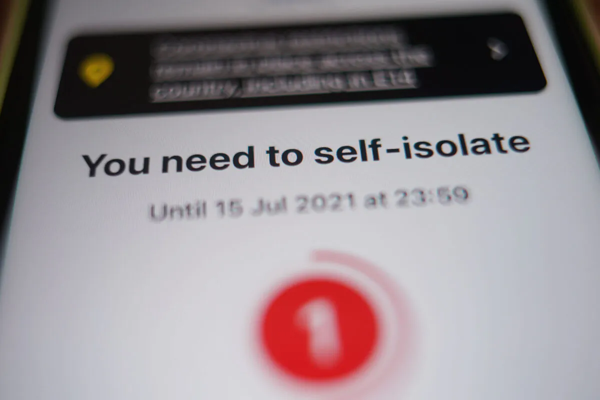 A message to self-isolate, with one day of required isolation remaining, is displayed on the NHS coronavirus contact tracing app on a mobile phone, in London, on July 15, 2021. (Yui Mok/PA)