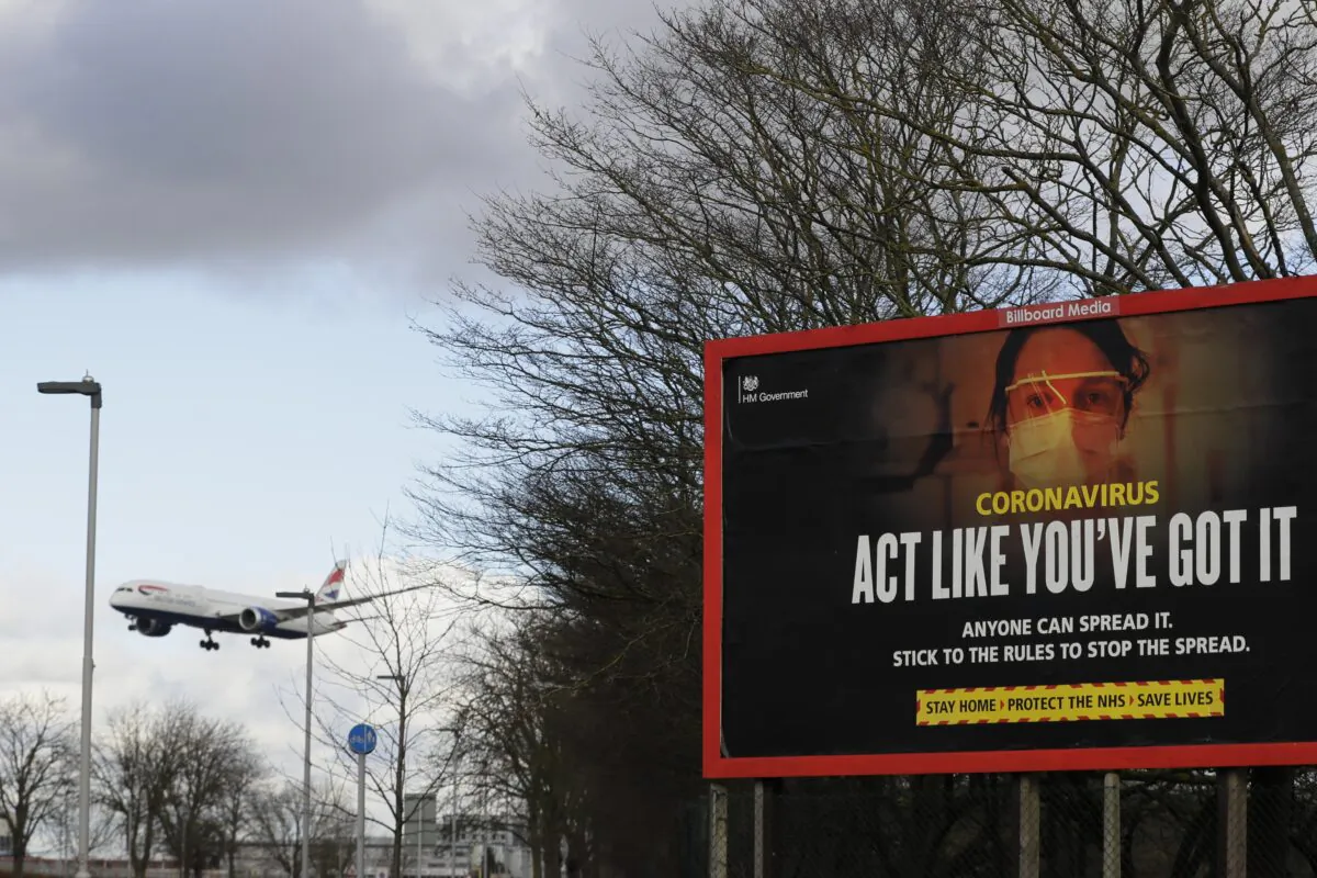 A plane comes in to land near a government coronavirus information sign at Heathrow Airport in London, on Feb. 5, 2021. (Kirsty Wigglesworth/AP Photo)