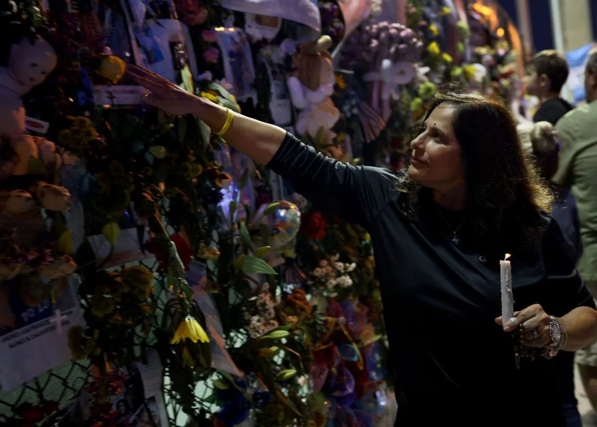 A woman visits the memorial that has pictures of some of the victims from the partially collapsed 12-story Champlain Towers South condo building in Surfside, Fla., on July 15, 2021. (Joe Raedle/Getty Images)