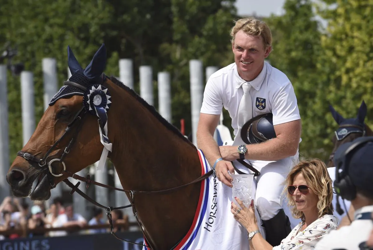 Australia's Jamie Kermond, riding Yandoo Oaks Constellation, receives his trophy after winning the High Jumping event of the second edition of the Longines Paris Eiffel Jumping tournament on the Champ de Mars in Paris on July 3, 2015. (Loic Venance/AFP via Getty Images)