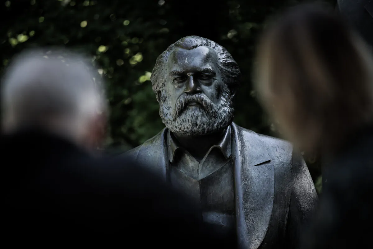 Visitors look at a statue of Karl Marx in a public park in Berlin on May 4, 2018. (Sean Gallup/Getty Images)