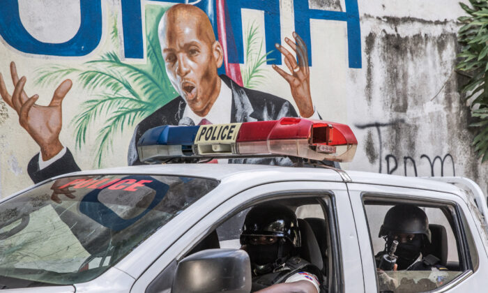 A police convoy drives past a wall painted with the president's image down the alley of the entrance to the residence of the president in Port-au-Prince, Haiti, on July 15, 2021. (Valerie Baeriswyl/AFP via Getty Images)
