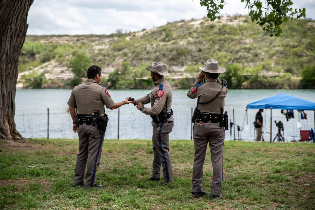 Texas State Troopers look across the river at a group of boys swimming in the Rio Grande near the border between Mexico and the United States in Del Rio, Texas on May 16, 2021. (Sergio Flores/AFP via Getty Images)