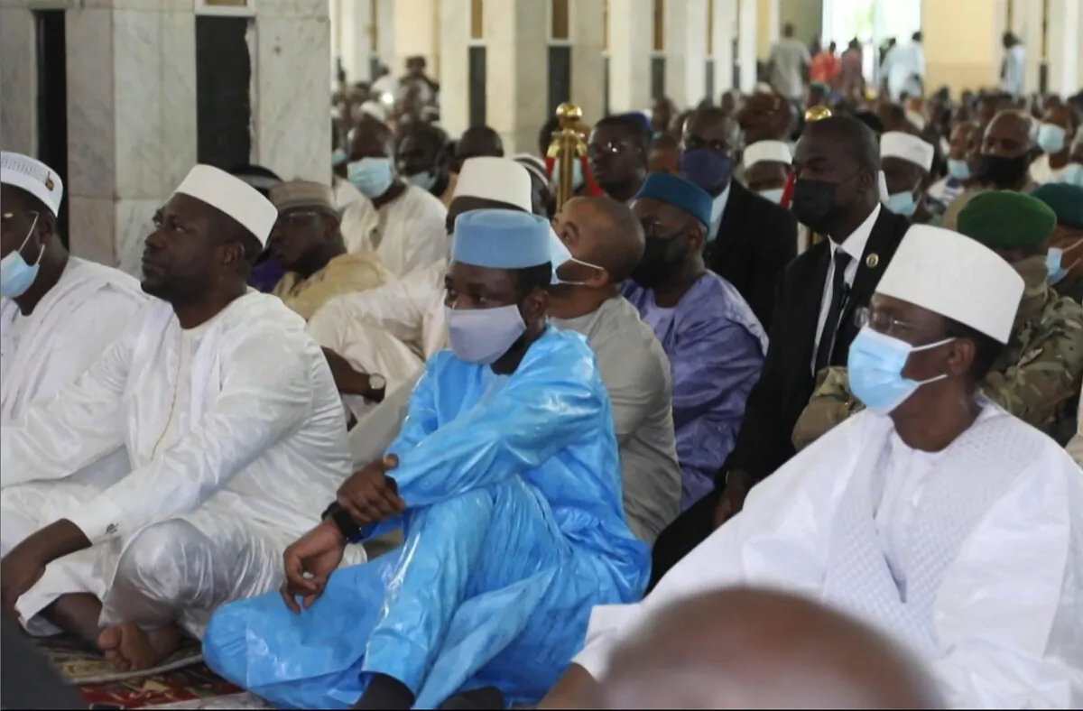 This image taken from video shows Mali's interim president Assimi Goita (C) as he sits with others during Eid al-Adha prayers at The Grande Mosque in Bamako, Mali, on July 20, 2021, before he was attacked by armed men. (Malick Konate/AFP via Getty Images)