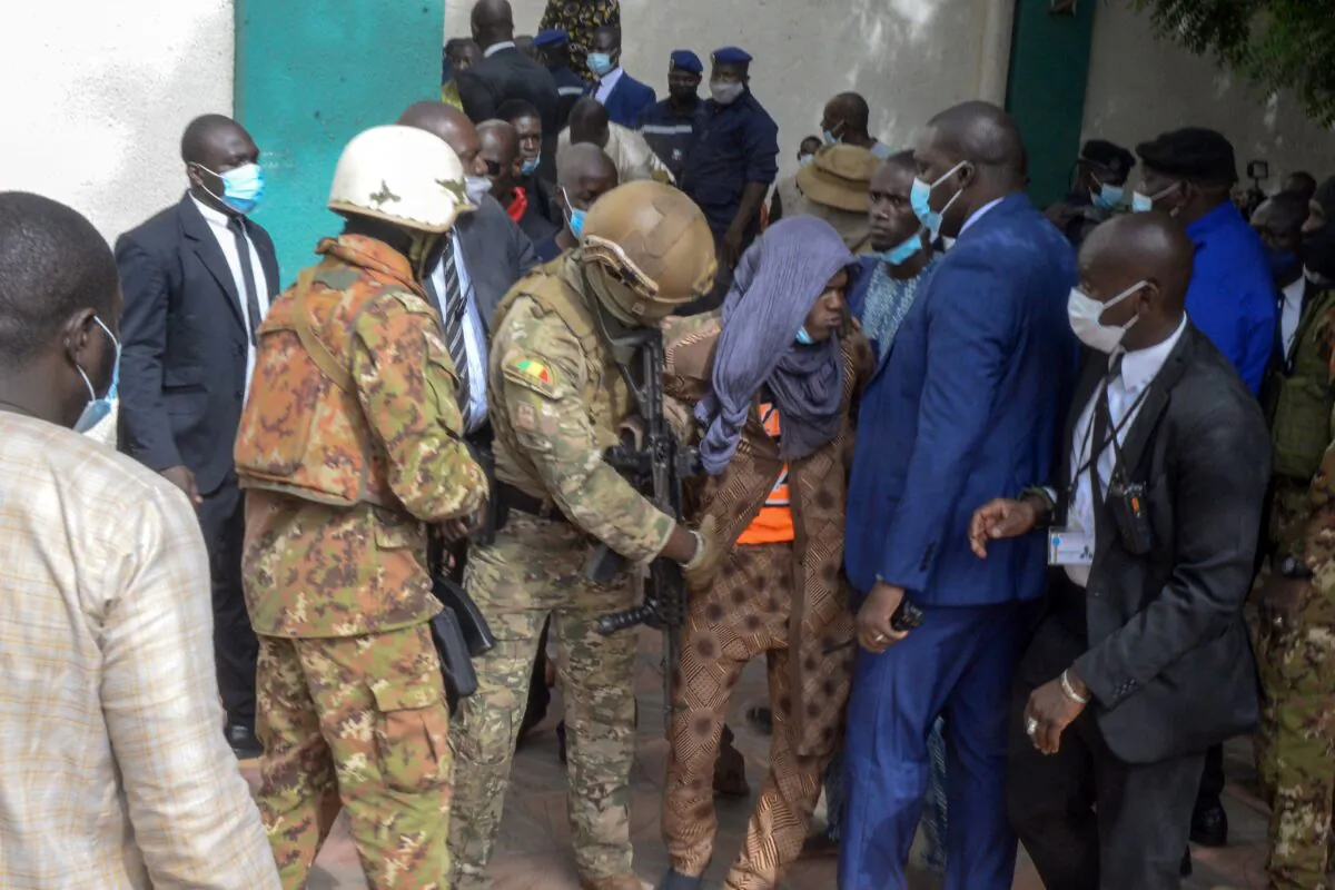 Security personnel escort an alleged attacker (C) from The Grand Fayçal Mosque in Bamako, Mali, on July 20, 2021. (Emmanuel Daou/AFP via Getty Images)