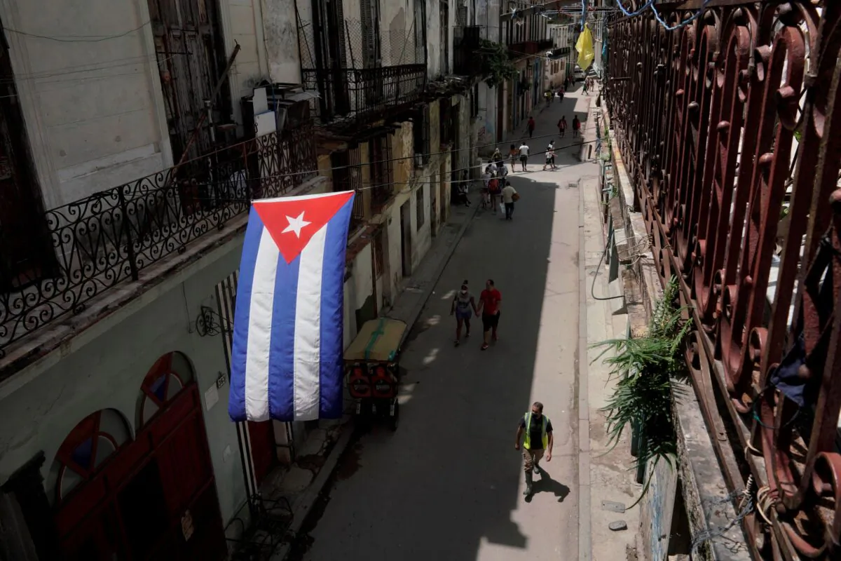 A Cuban flag hangs over a street in downtown Havana, Cuba, on July 15, 2021. (Alexandre Meneghini/Reuters(
