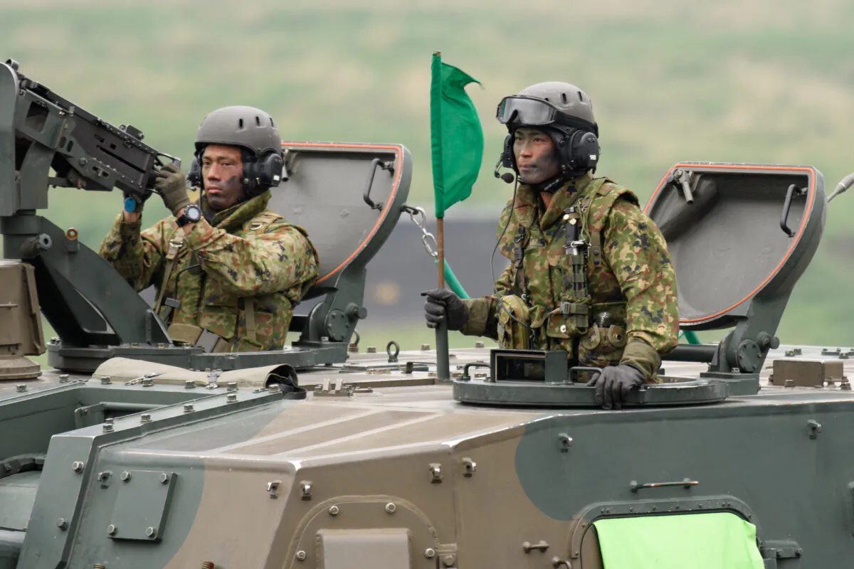 Japan's Ground Self-Defense Forces (JGSDF) soldiers ride a Type 99 155mm self-propelled howitzer during a live fire exercise at JGSDF's training grounds in the East Fuji Maneuver Area in Gotemba city, Shizuoka Prefecture, Japan, on May 22, 2021. (Akio Kon/Pool/Getty Images)