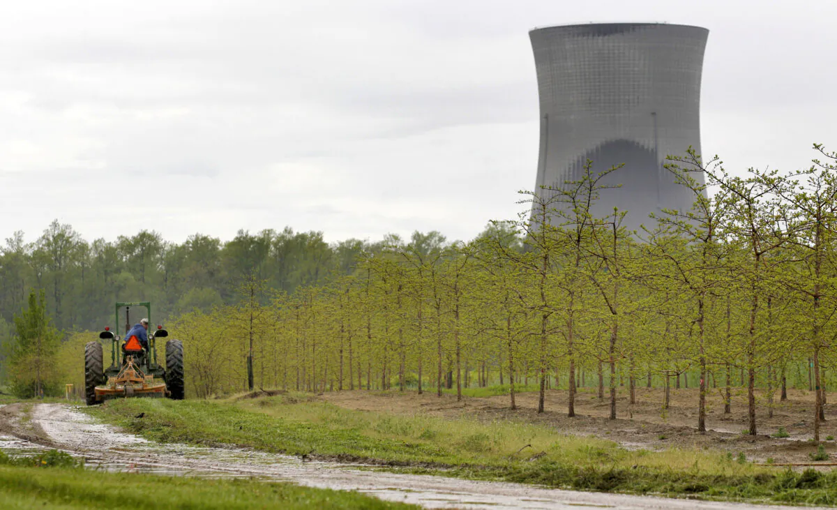 A worker drives a tractor through a tree farm in North Perry, Ohio, near the cooling towers of the Perry Nuclear Power Plant on May 18, 2011. (Amy Sancetta, File/AP Photo)