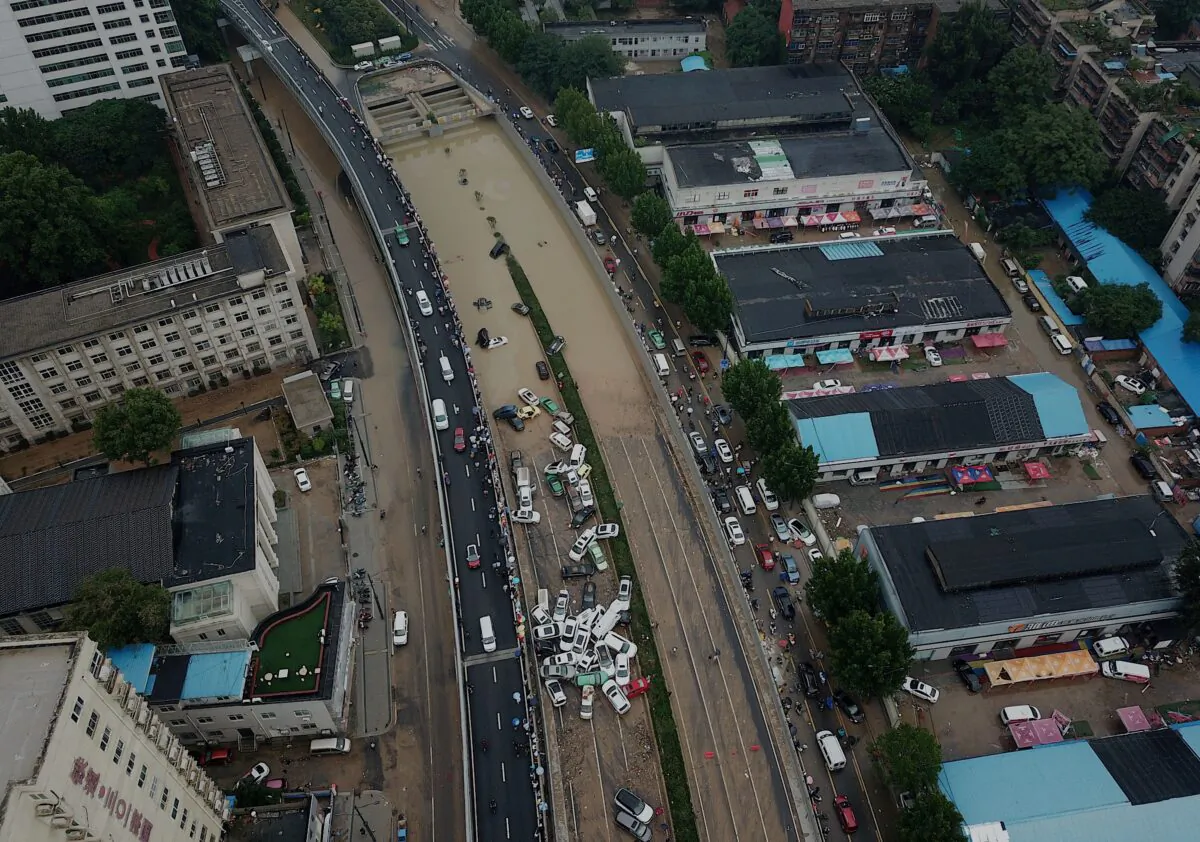 An aerial view shows cars sitting in floodwaters at the entrance of Jingguang Expressway tunnel after heavy rains hit the city of Zhengzhou in China's central Henan province on July 22, 2021. (Noel Celis / AFP) 