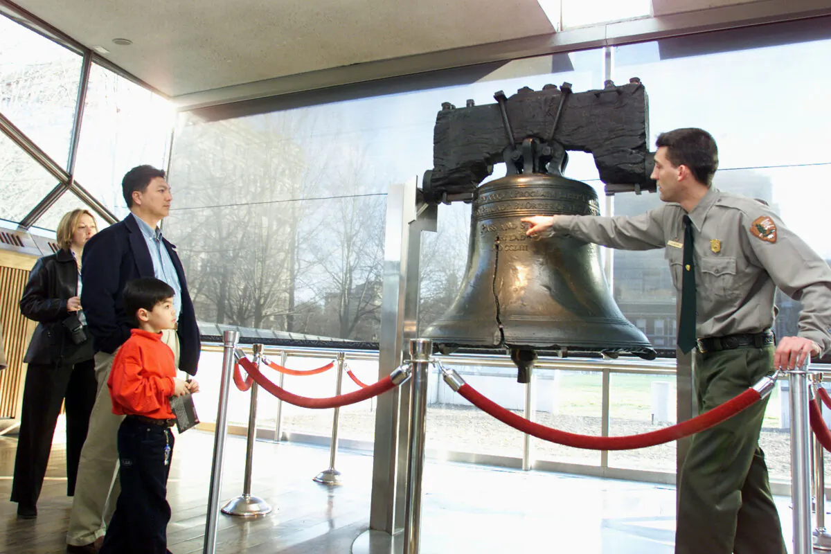 A National Park Service ranger points out the larger of two cracks in the Liberty Bell to a family in Philadelphia, on Feb. 21, 2002.  (Don Murray/Getty Images)
