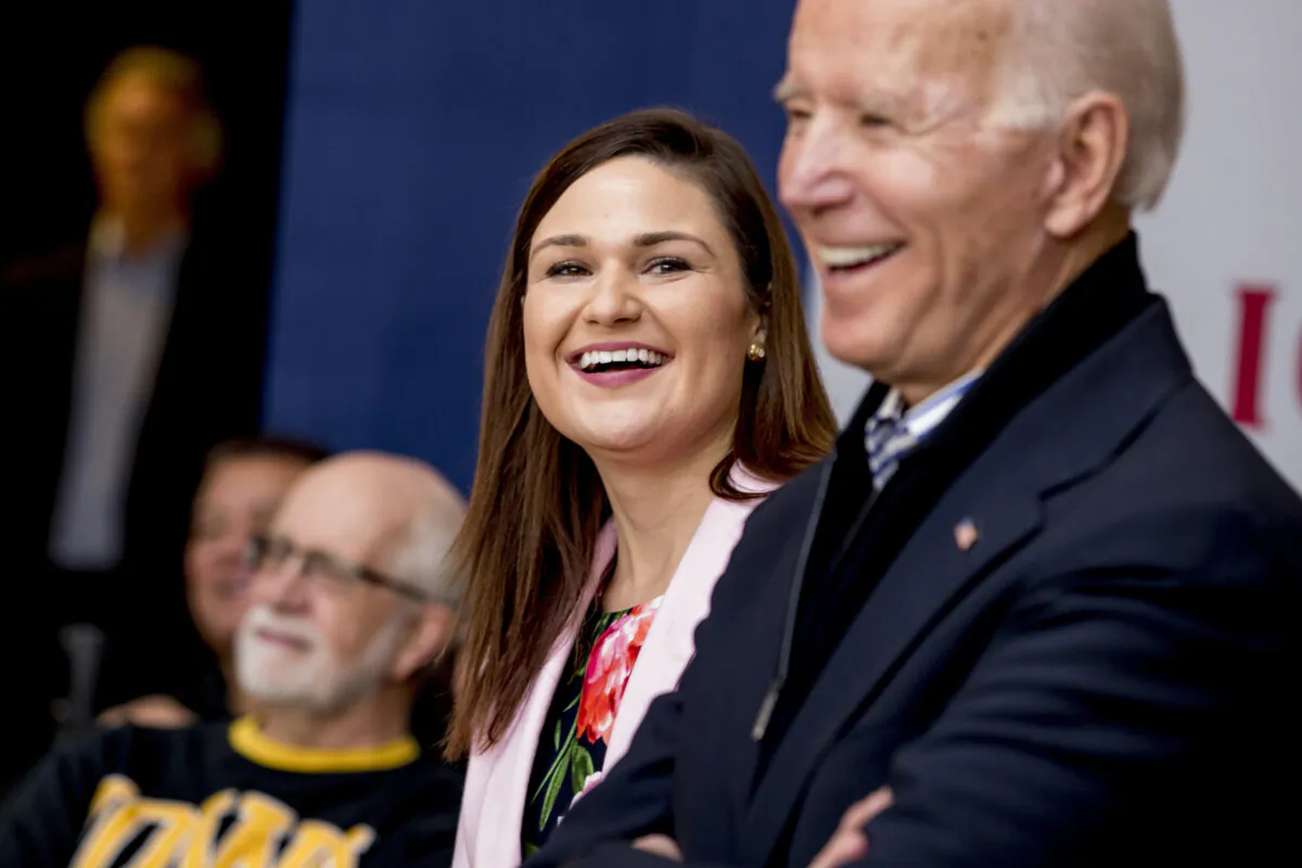 Democratic presidential candidate Joe Biden (R), and Rep. Abby Finkenauer, D-Iowa (C), smile during a campaign rally at the University of Dubuque, in Dubuque, Iowa on Jan. 3 2020. (Andrew Harnik/AP Photo)