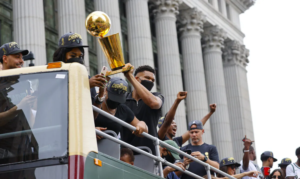 Milwaukee Bucks' Giannis Antetokounmpo holds up the NBA Championship trophy during a parade and celebration for the basketball team in Milwaukee, Wis., on July 22, 2021. (Jeffrey Phelps/AP Photo)