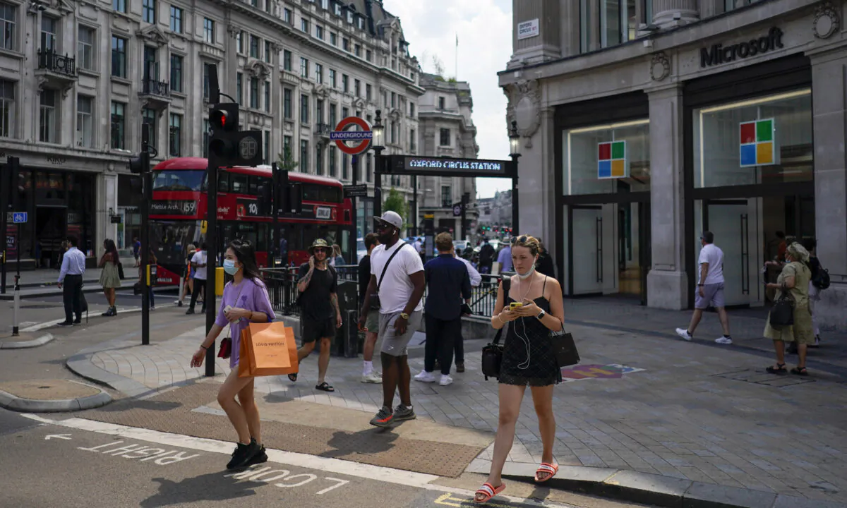 People walk in Oxford Circus in London on July 19, 2021. (Alberto Pezzali/AP Photo)