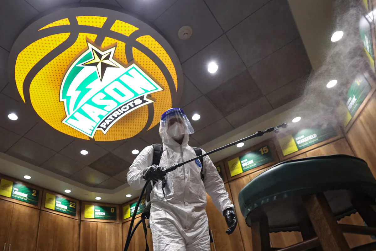 A worker uses a sanitizer to sterilize the George Mason Patriots basketball locker room, in Fairfax, Va., on Jan. 13, 2021. (Patrick Smith/Getty Images)