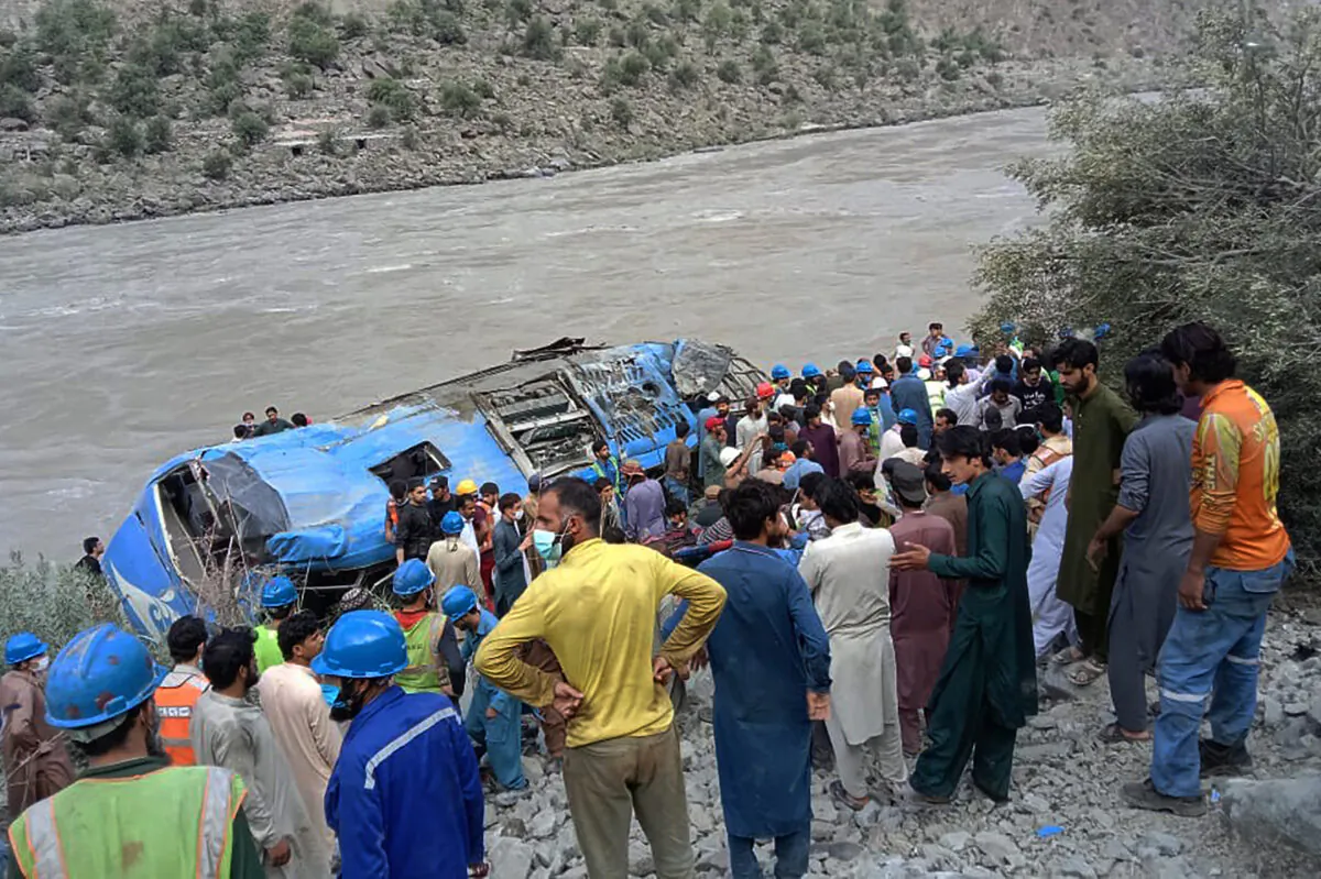 Rescue workers and onlookers gather around a wreck after a bus plunged into a ravine following a bomb explosion, which killed 12 people including 9 Chinese workers, in Kohistan district of Khyber Pakhtunkhwa province on July 14, 2021. (Stringer/AFP via Getty Images)