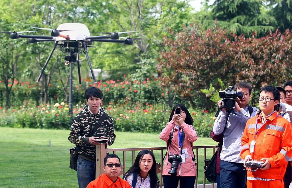 This picture, taken on May 12, 2015, shows people watching a demonstration of an unmanned drone during a campaign for disaster prevention and reduction in Beijing. China forbids any flights, manned or unmanned, without prior approval from the air force, civil aviation authorities, and the local air traffic control bureau. (STR/AFP via Getty Images)