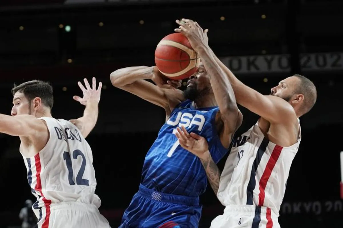United States' forward Kevin Durant (7) and France's Evan Fournier fight for control of the ball during a men's basketball preliminary round game at the 2020 Summer Olympics in Saitama, Japan, on July 25, 2021. (AP Photo/Eric Gay)