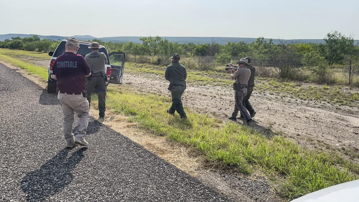 Texas, Nebraska, and Iowa State Troopers, along with Border Patrol and the Kinney County Constable, prepare to search a stolen vehicle in Kinney County, Texas, on July 21, 2021. (Charlotte Cuthbertson/The Epoch Times)