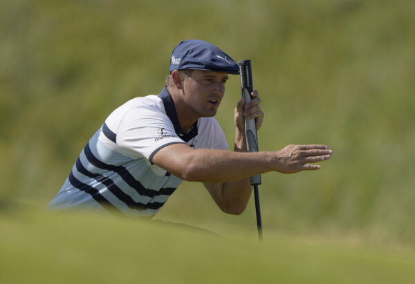 Bryson DeChambeau gestures as he lines up his putt