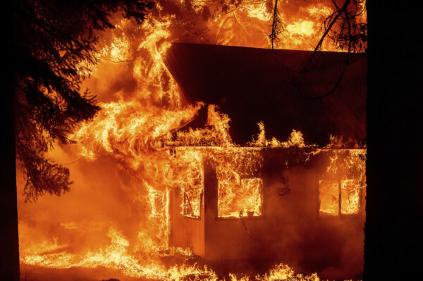 Flames consume a home as the Dixie Fire