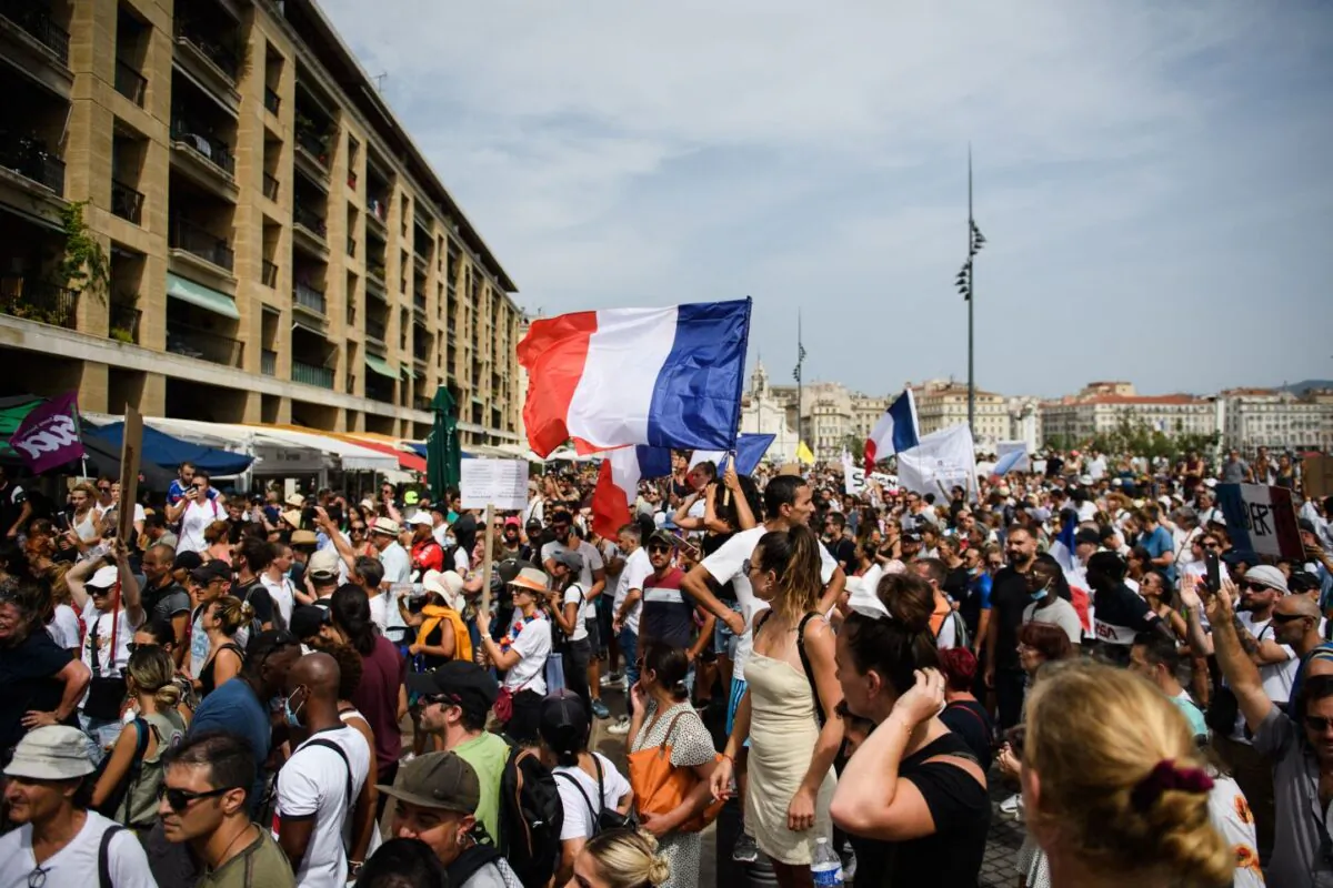 A protestor waves a French national flag during a demonstration against compulsory vaccination for certain workers and the mandatory use of the health pass called by the French government, in Marseille, southern France on July 24, 2021. (Clement Mahoudeau/AFP via Getty Images)
