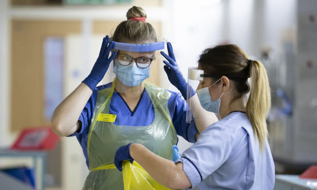 Nurses changing their PPE on Ward 5, a COVID Red Ward, at the Royal Alexandra Hospital in Paisley, Scotland, on Jan. 27, 2021. (Jane Barlow/PA)
