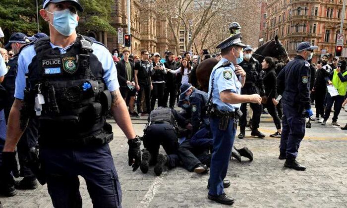 A protester is arrested by police at Sydney Town Hall during the ‘World Wide Rally For Freedom’ anti-lockdown rally at Hyde Park in Sydney, Saturday, July 24, 2021. (AAP Image/Mick Tsikas)