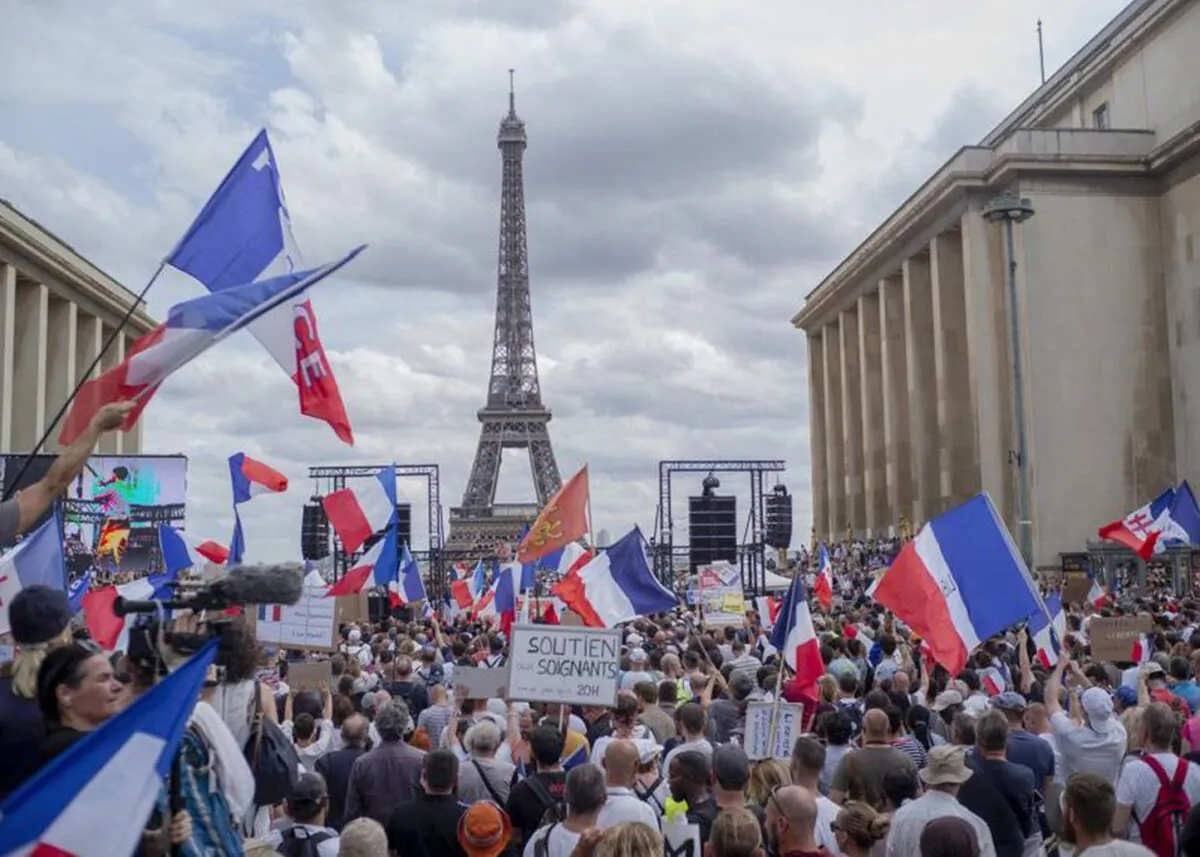 Thousands of protesters gather at Place Trocadero near the Eiffel Tower attend a demonstration in Paris, on July 24, 2021, against the COVID-19 pass, which grants vaccinated individuals greater ease of access to venues. (AP Photo/Rafael Yaghobzadeh)