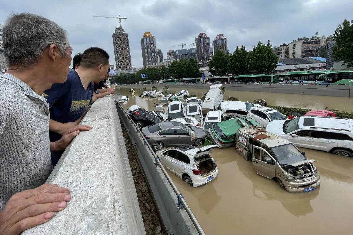 People look out at cars sitting in floodwaters after heavy rains hit the city of Zhengzhou, Henan Province, China, on July 21, 2021. (STR/AFP via Getty Images)