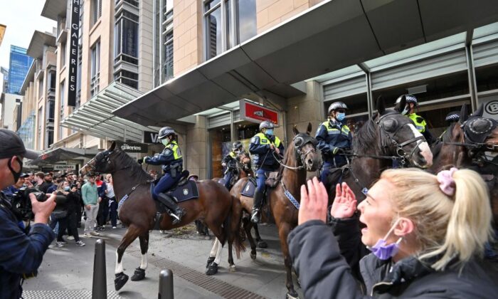 Police officers on horseback disperse protesters during a rally in Sydney, Australiaon July 24, 2021, as thousands of people gathered to demonstrate against the city's month-long stay-at-home orders. (Steven Saphore/AFP via Getty Images)