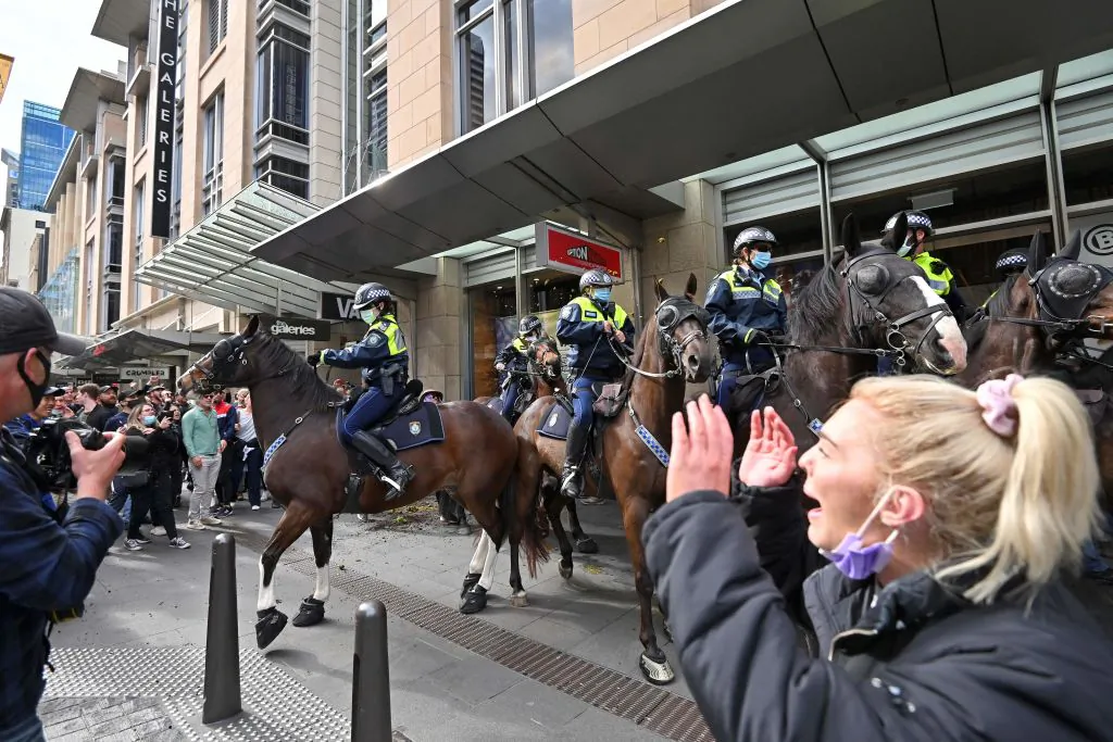 Police officers on horseback disperse protesters during a rally in Sydney, Australiaon July 24, 2021, as thousands of people gathered to demonstrate against the city's month-long stay-at-home orders. (Steven Saphore/AFP via Getty Images)