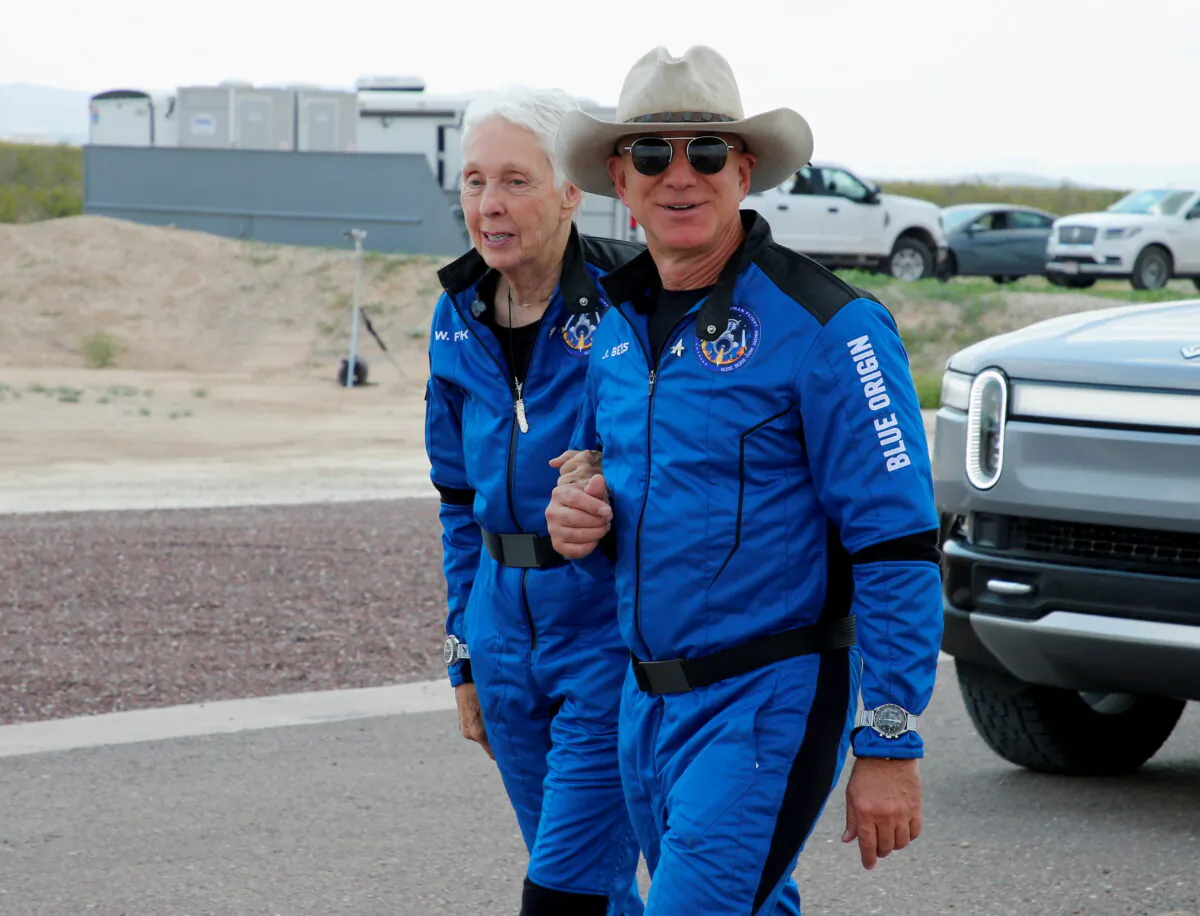 Billionaire American businessman Jeff Bezos walks with crew mate Wally Funk at the landing pad after they flew on Blue Origin's inaugural flight to the edge of space, in the nearby town of Van Horn, Texas, United States, on July 20, 2021. (Joe Skipper/Reuters)