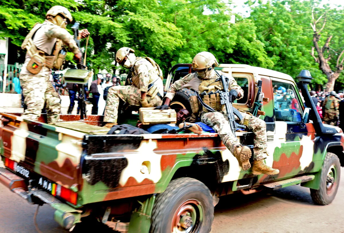 An assailant who attempted to stab Mali's interim president Colonel Assimi Goita during the Eid Al Adha prayer, is seen lying in an army vehicle after he was arrested in Bamako, Mali  July 20, 2021. (Stringer/Reuters)