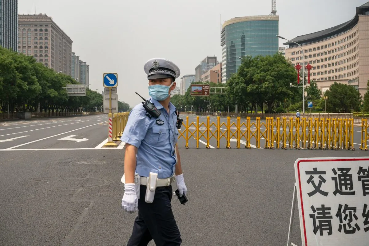 A policeman stands by a barrier to prevent cars from accessing Chang'an Jie, Beijing's main road leading to Tiananmen Square, in Beijing on July 1, 2021. (Andrea Verdelli/Getty Images)