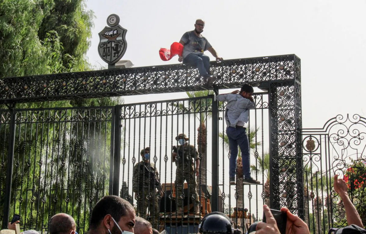 Tunisian soldiers guard the main entrance of the parliament as demonstrators gather outside the the gate in Tunis, Tunisia, on July 26, 2021. (Hedi Azouz/AP Photo)