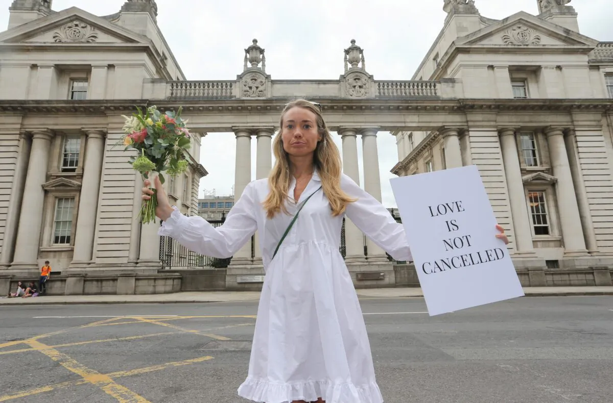 Orla O'Huadaigh holds up a sign at a protest march to Government Buildings in a bid to allow up to 100 guests to attend weddings this year in Dublin, Ireland, on July 27, 2021. (Lorraine O'Sullivan/Reuters)