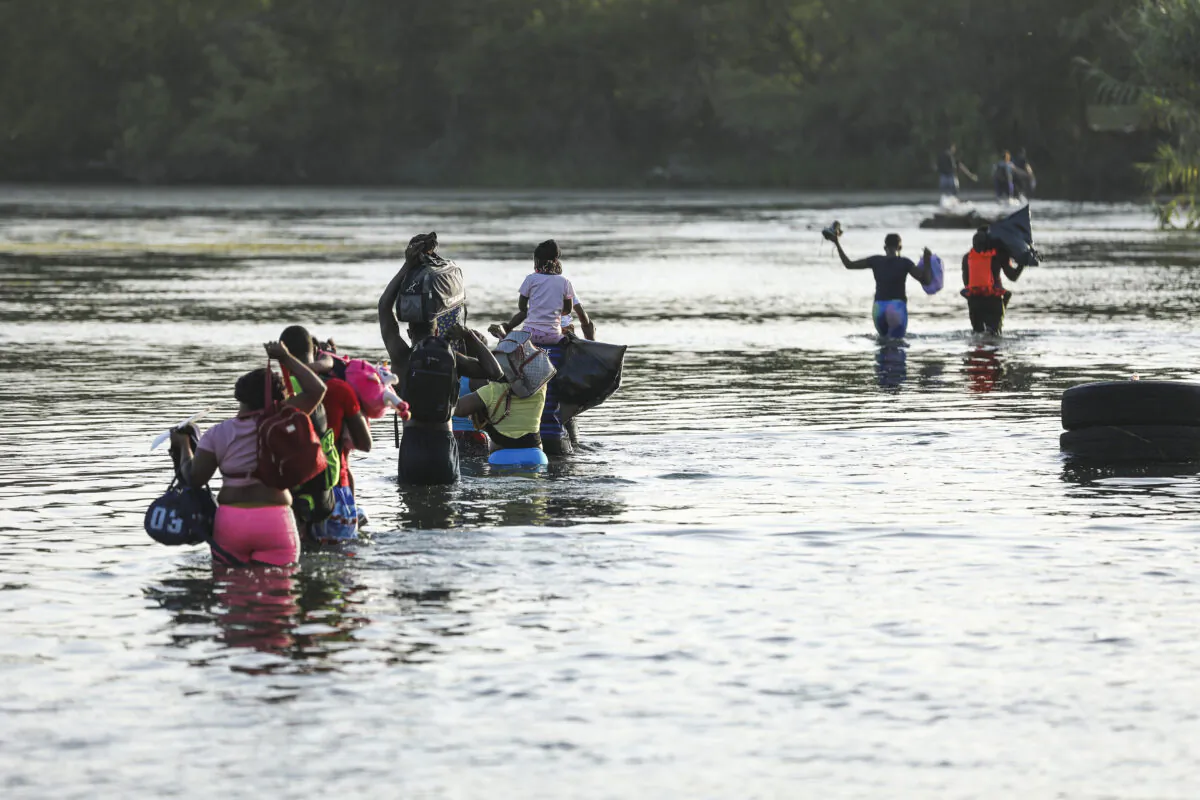 A group of illegal immigrants crosses the Rio Grande from Acuña, Mexico, to Del Rio, Texas, on July 25, 2021. (Charlotte Cuthbertson/The Epoch Times)