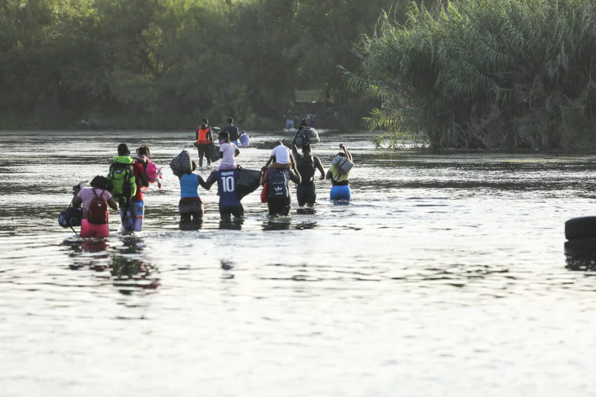 A group of illegal immigrants crosses the Rio Grande from Acuña, Mexico, to Del Rio, Texas, on July 25, 2021. (Charlotte Cuthbertson/The Epoch Times)
